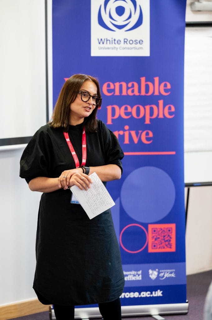 _SKY8978 A speaker standing in front of a White Rose banner