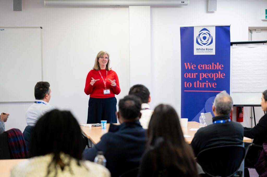 _SKY9118 Karen Hinxman addressing the room next to a White Rose banner
