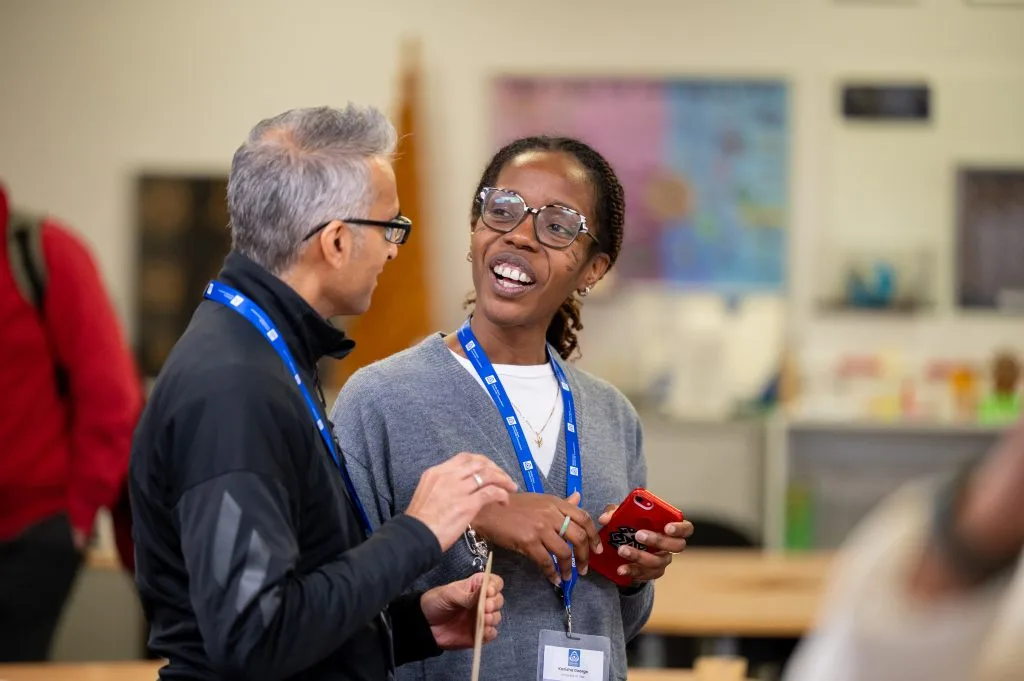 Two participants smiling and chatting during a networking break