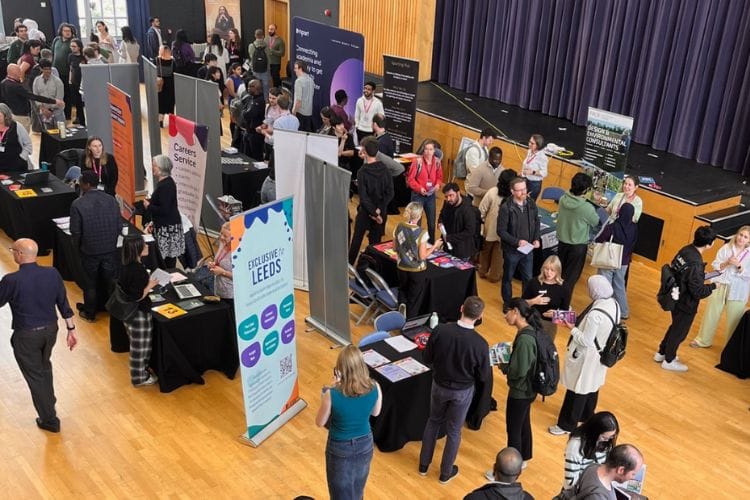 Researchers and employers networking around display stands at the PhD Careers Fair