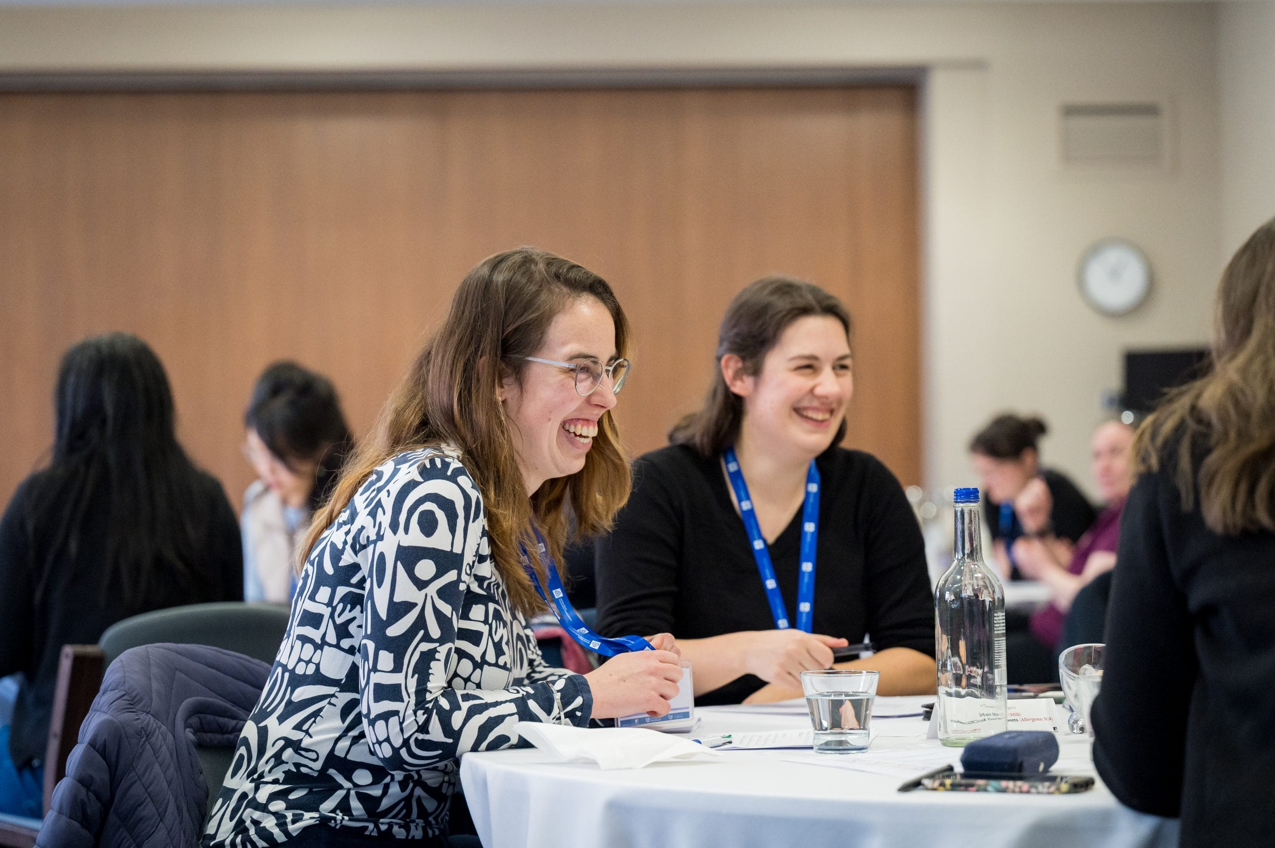 Two women sitting and table and laughing